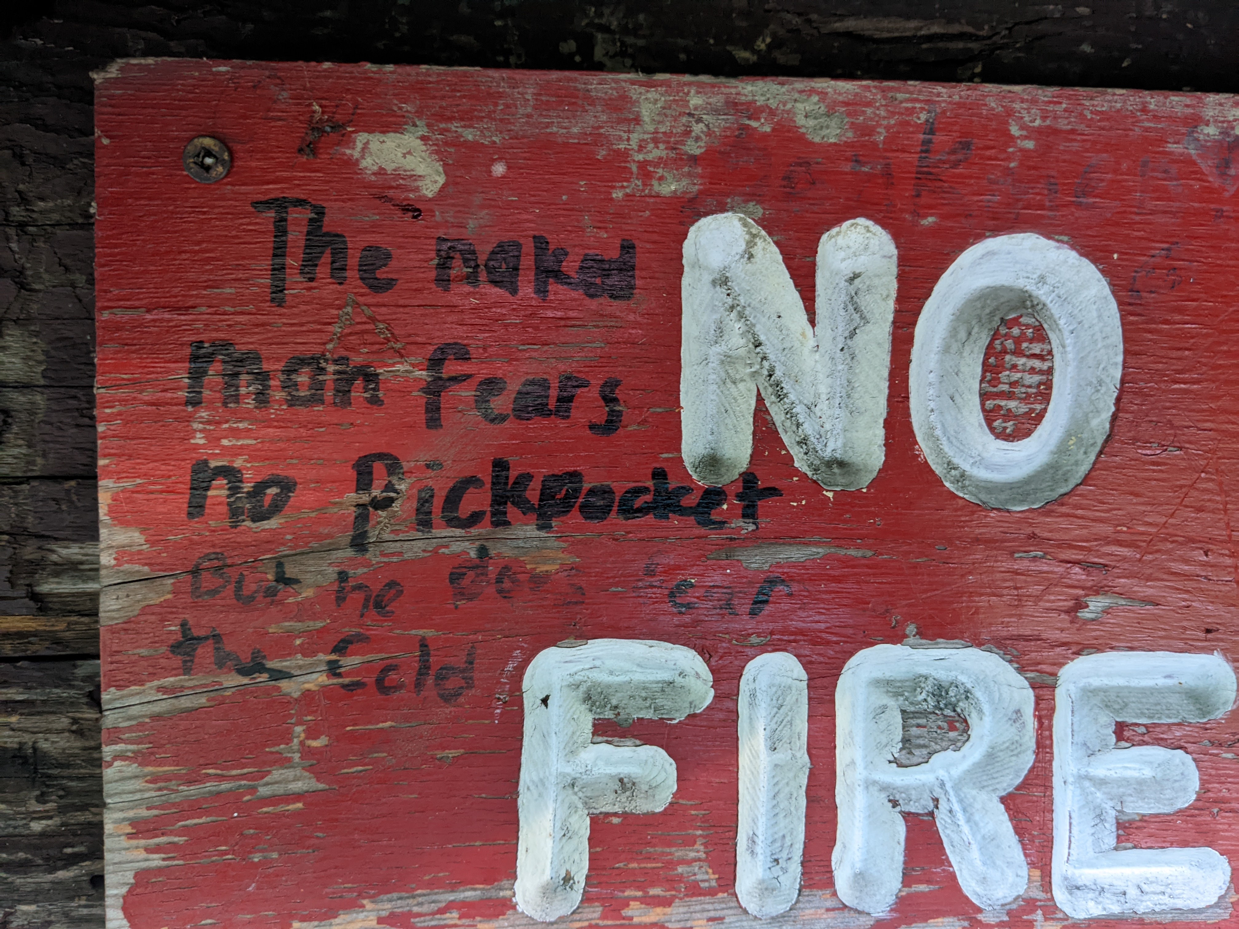 Graffit that says a naked man fears no pickpocket, but does fear the cold